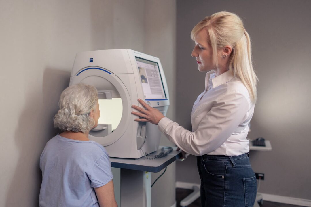 Perimetrie: Die Mitarbeiterin kontrolliert die Position der Patientin.